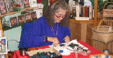 Joan Wells demonstrating the making of feather jewelry.