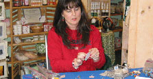 Tina Stone demonstrating the making of lampwork jewelry.